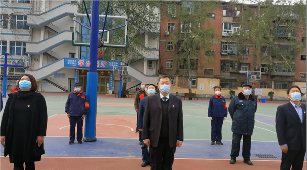 6参加升旗仪式的人员凝视国旗，行注目礼.png