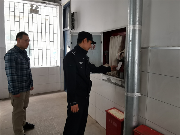 图为郭警官检查学校消防设施.jpg