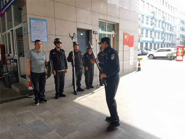 图为郭文瑞警官向学校安保人员教授安保器械使用方法.jpg